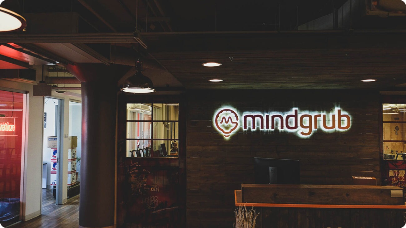 The Mindgrub office front lobby. A neon sign of the Mindgrub logo hung above the front desk.