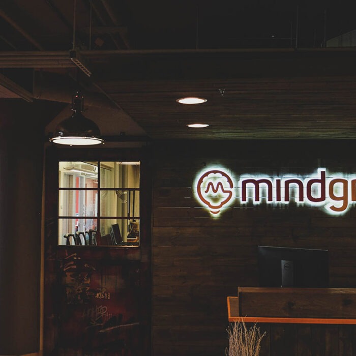 The Mindgrub office front lobby. A neon sign of the Mindgrub logo hung above the front desk.