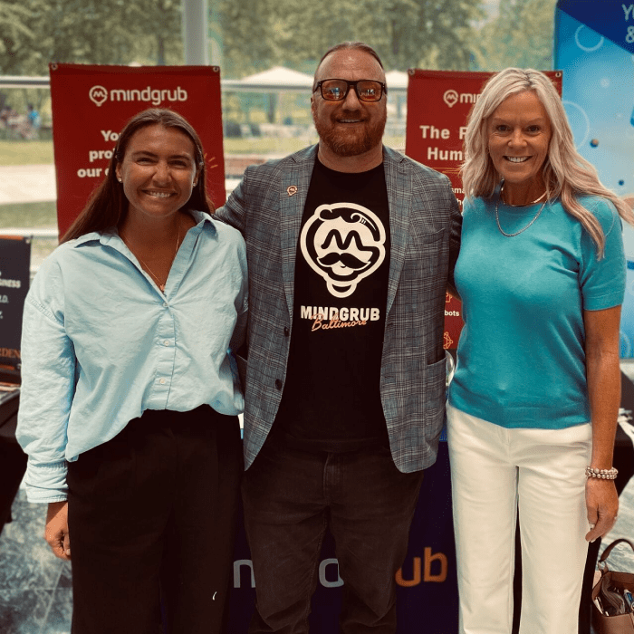3 Mindgrub employees standing together and smiling.