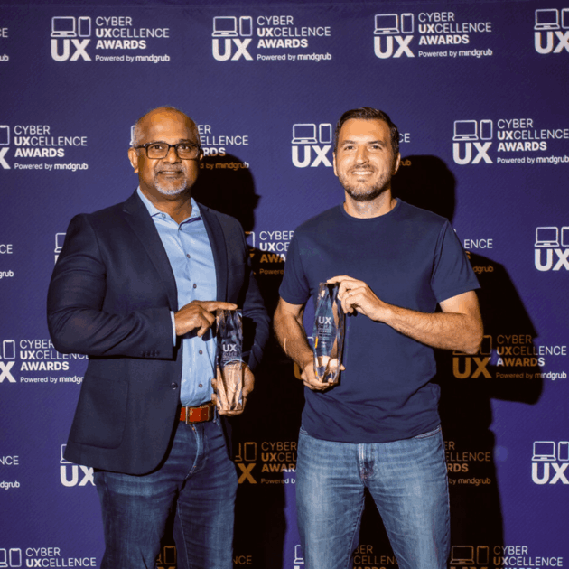 Two winners holding their trophies at the awards ceremony