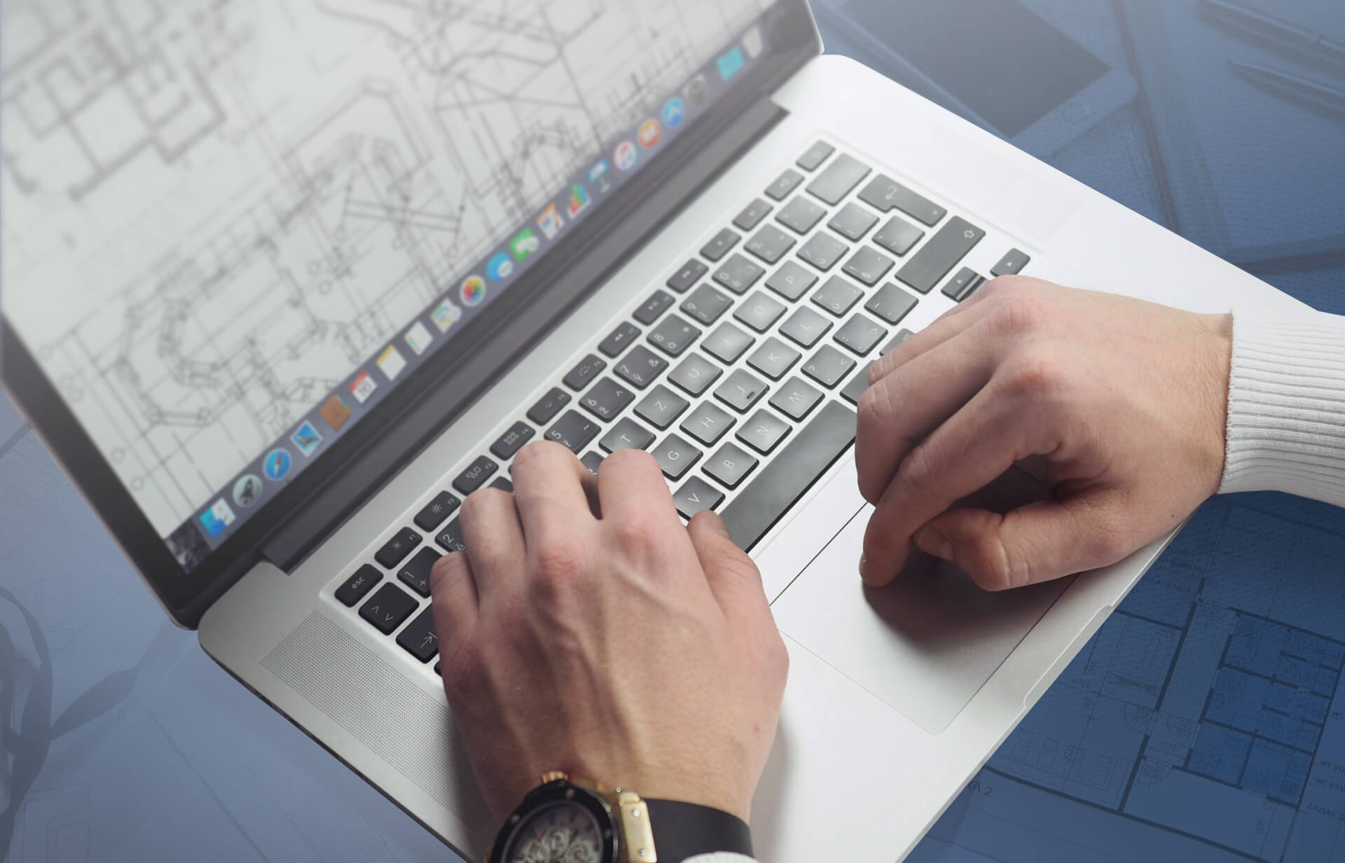 Person working with architectural floor plans on a laptop.