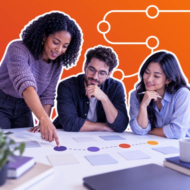Three people collaborating on a project roadmap, with one pointing to milestones on a table.